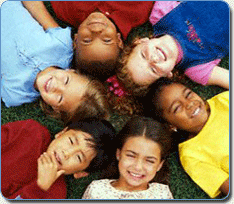 happy children lying on the grass forming a circle